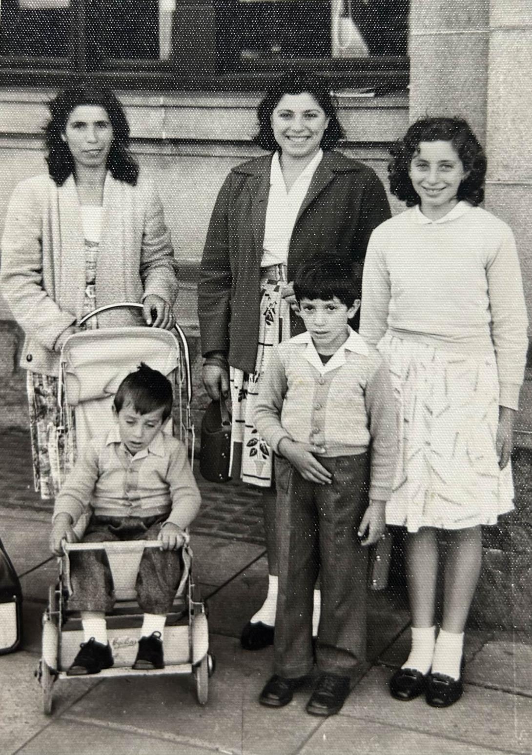 The family gather beside the youngest who is in a pram.