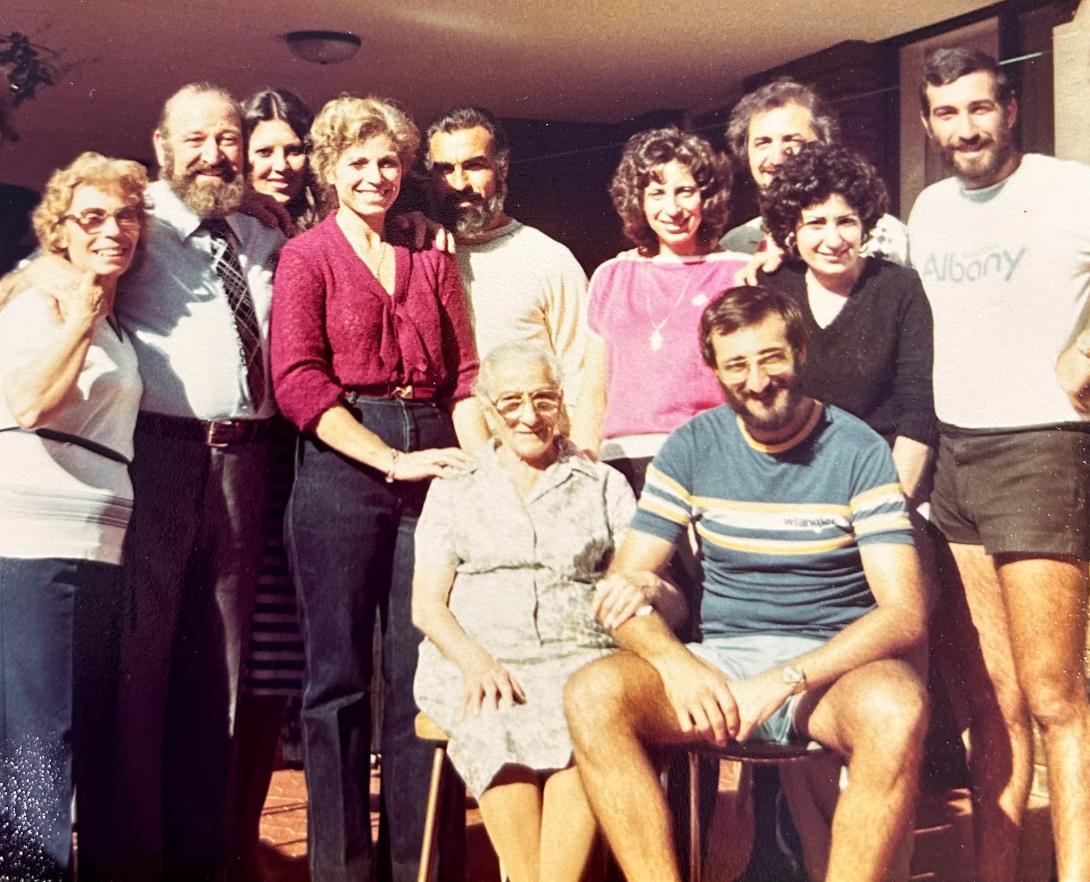 Eleven family members smiling at the camera, all are adults.