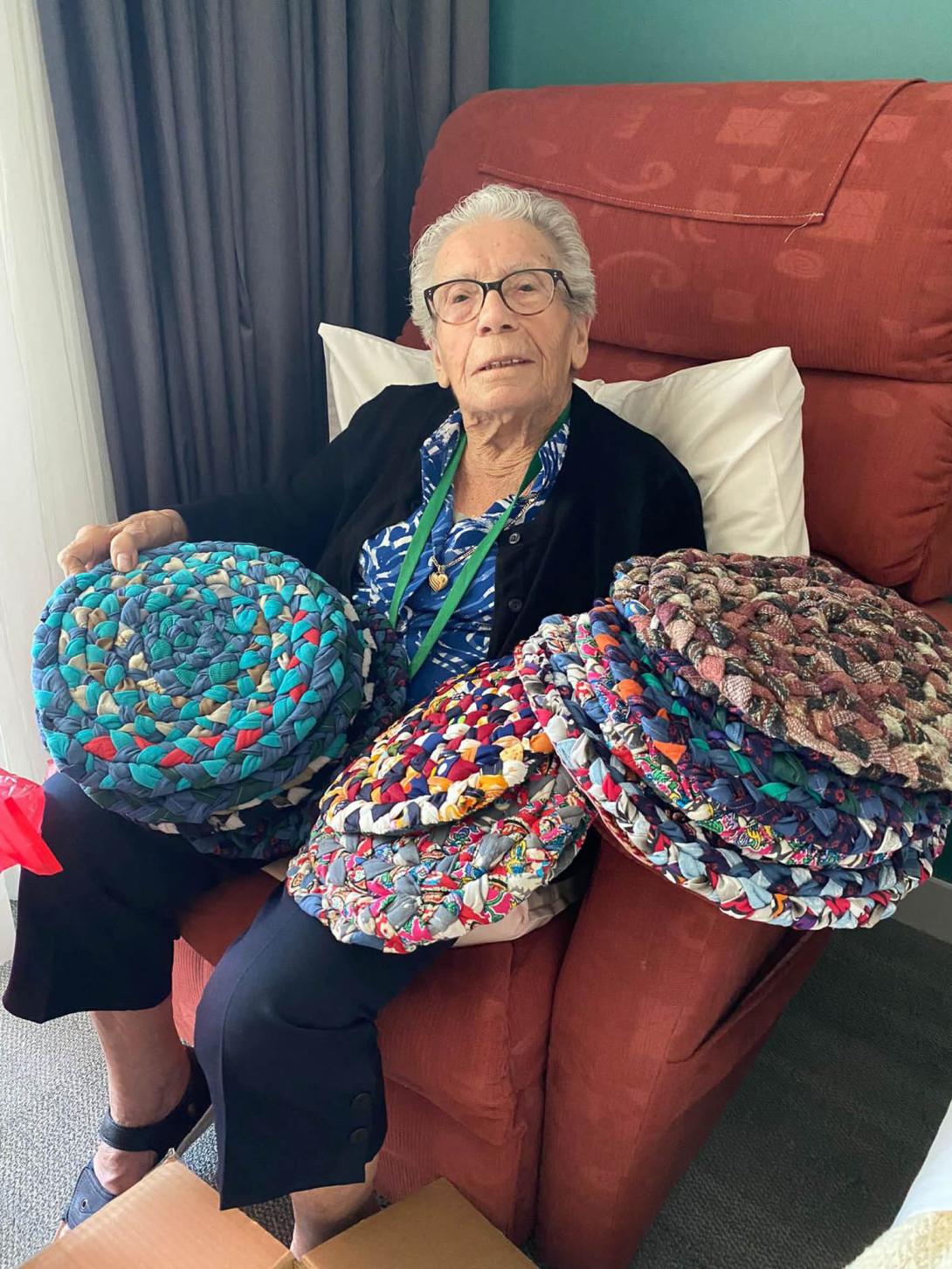 Carolina looking almost swamped by a couple of piles of colourful fabric items.