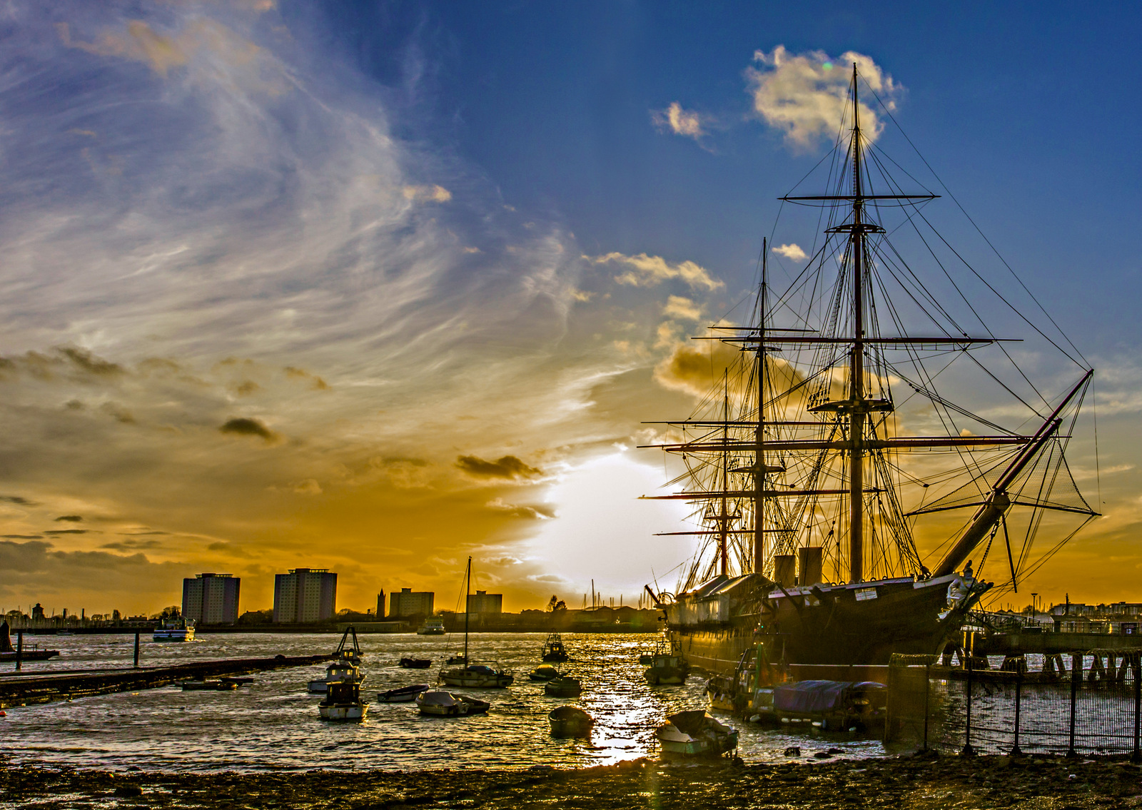 a sunset image of a ship in a marina
