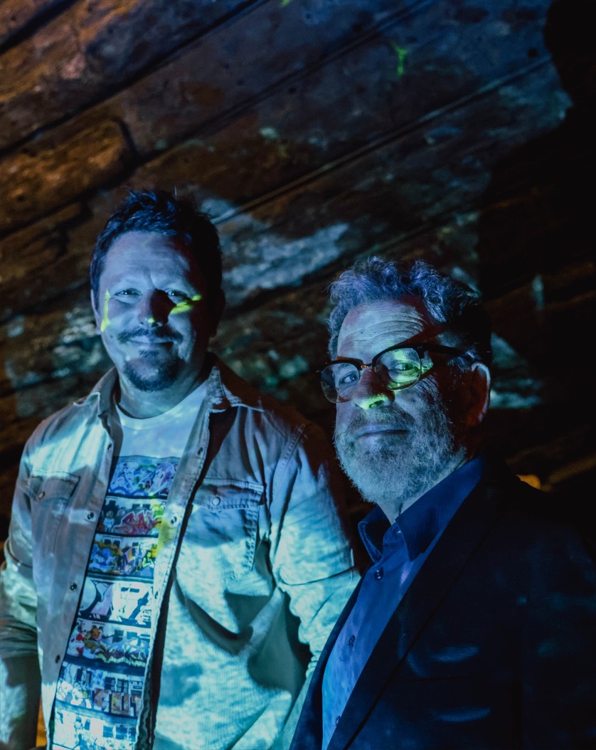 Filmmaker Brendan Hutchens and musician Lucky Oceans lit by ocean video projection onto the hull timbers of the Batavia in WA Shipwrecks Museum for the Tides music event (Fremantle Festival - 10 Nights in Port 2026).