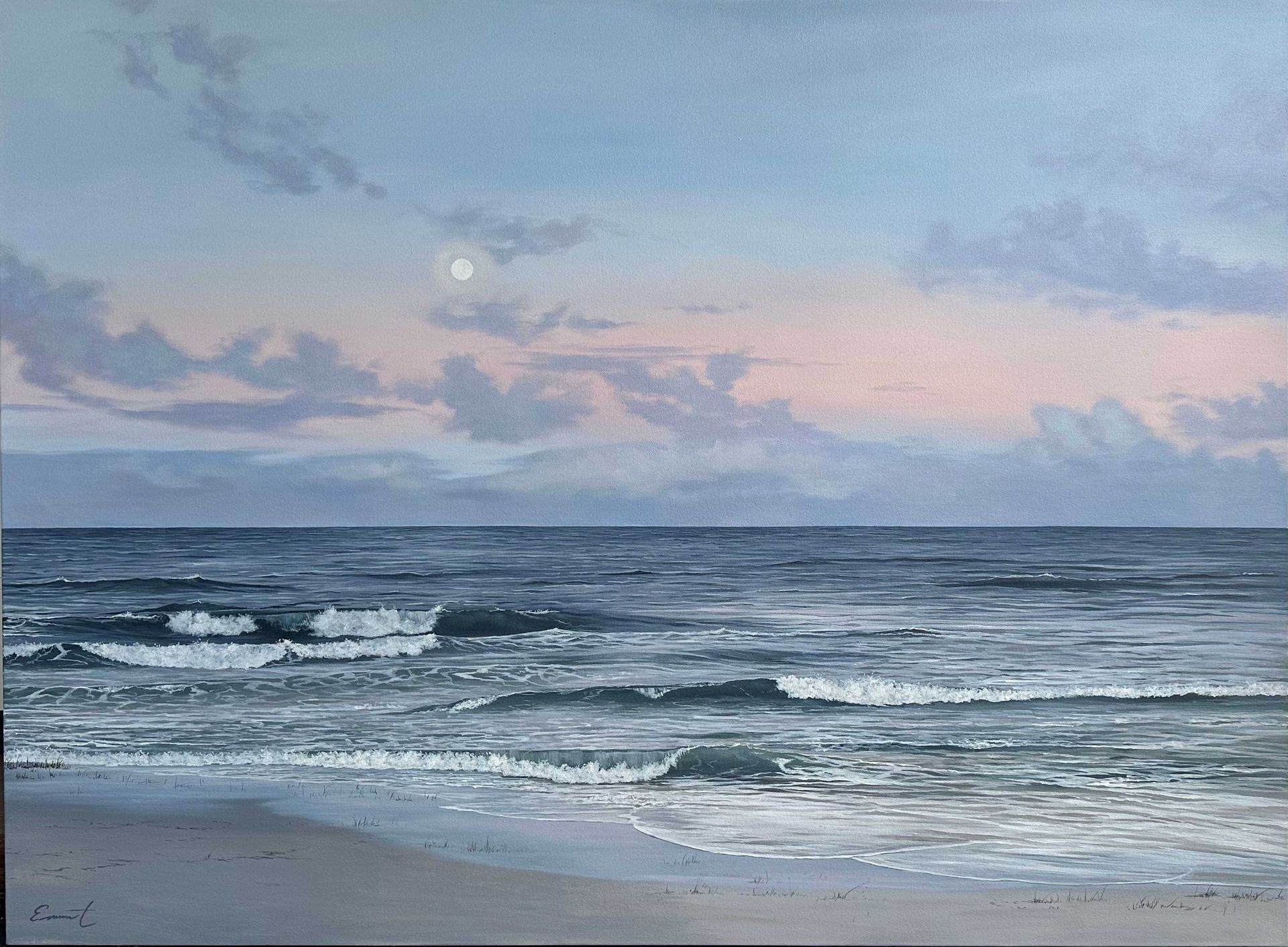 A tranquil seascape showing gentle waves rolling onto a sandy beach beneath a pastel evening sky. Soft pink and blue clouds surround a pale moon above the horizon, reflecting the calm atmosphere of twilight.