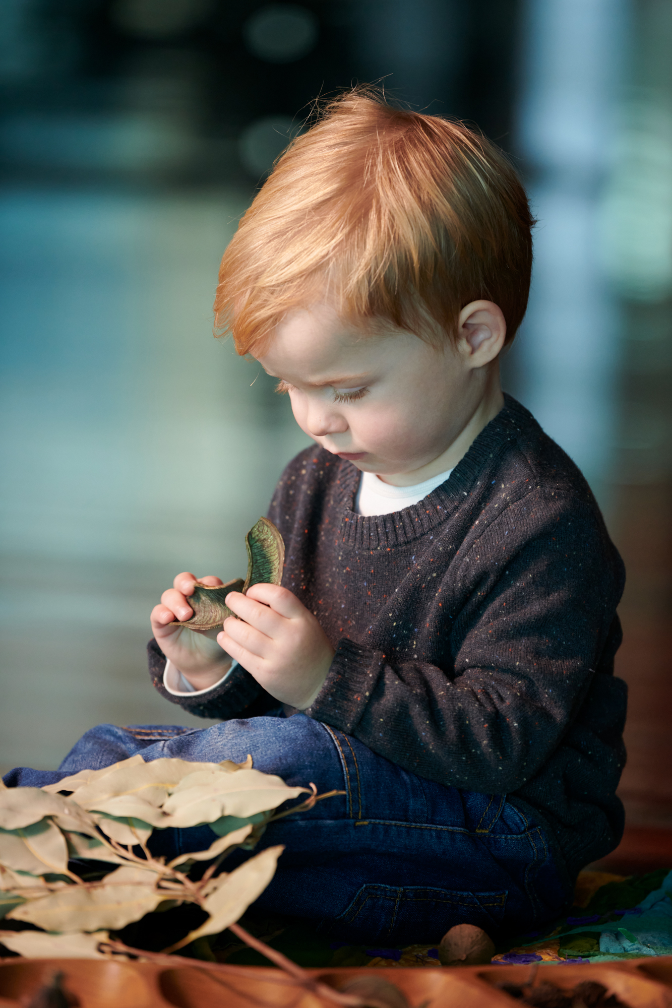 a young child of toddler age examines some garden foliage