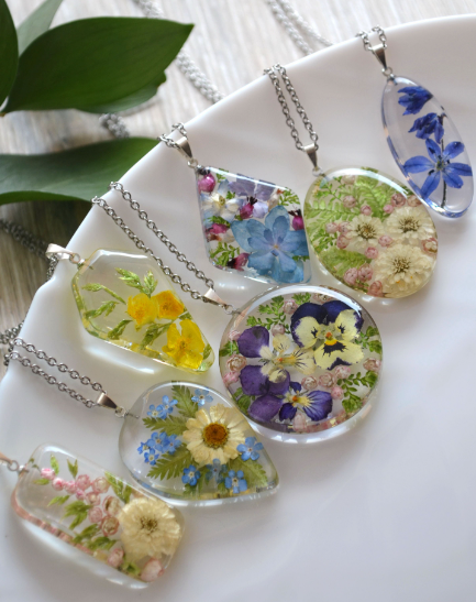 a view of a collection of six pendant resin jewellery with flowers and leaves in the art piece