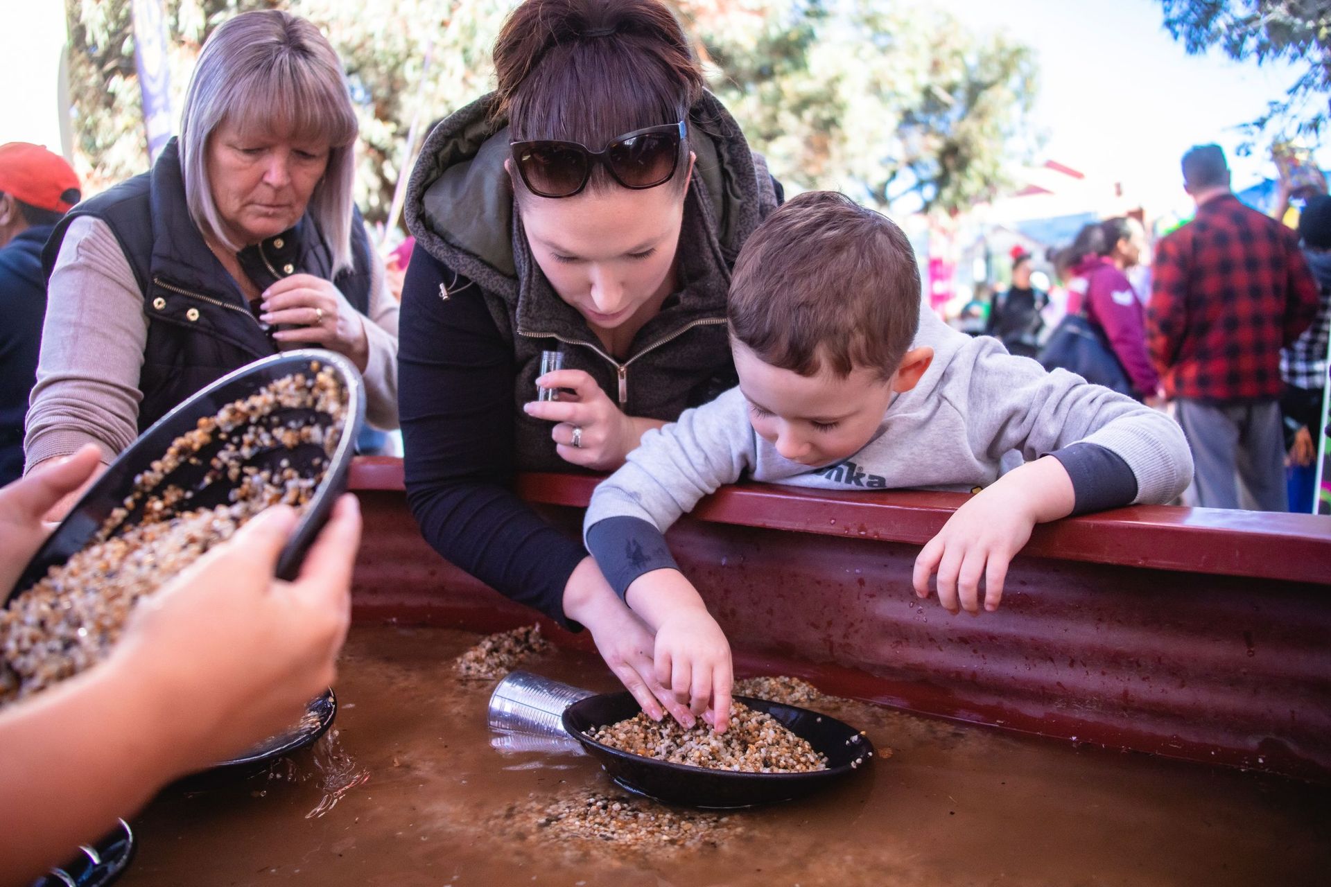 Mother and son shift through dirt to find gold
