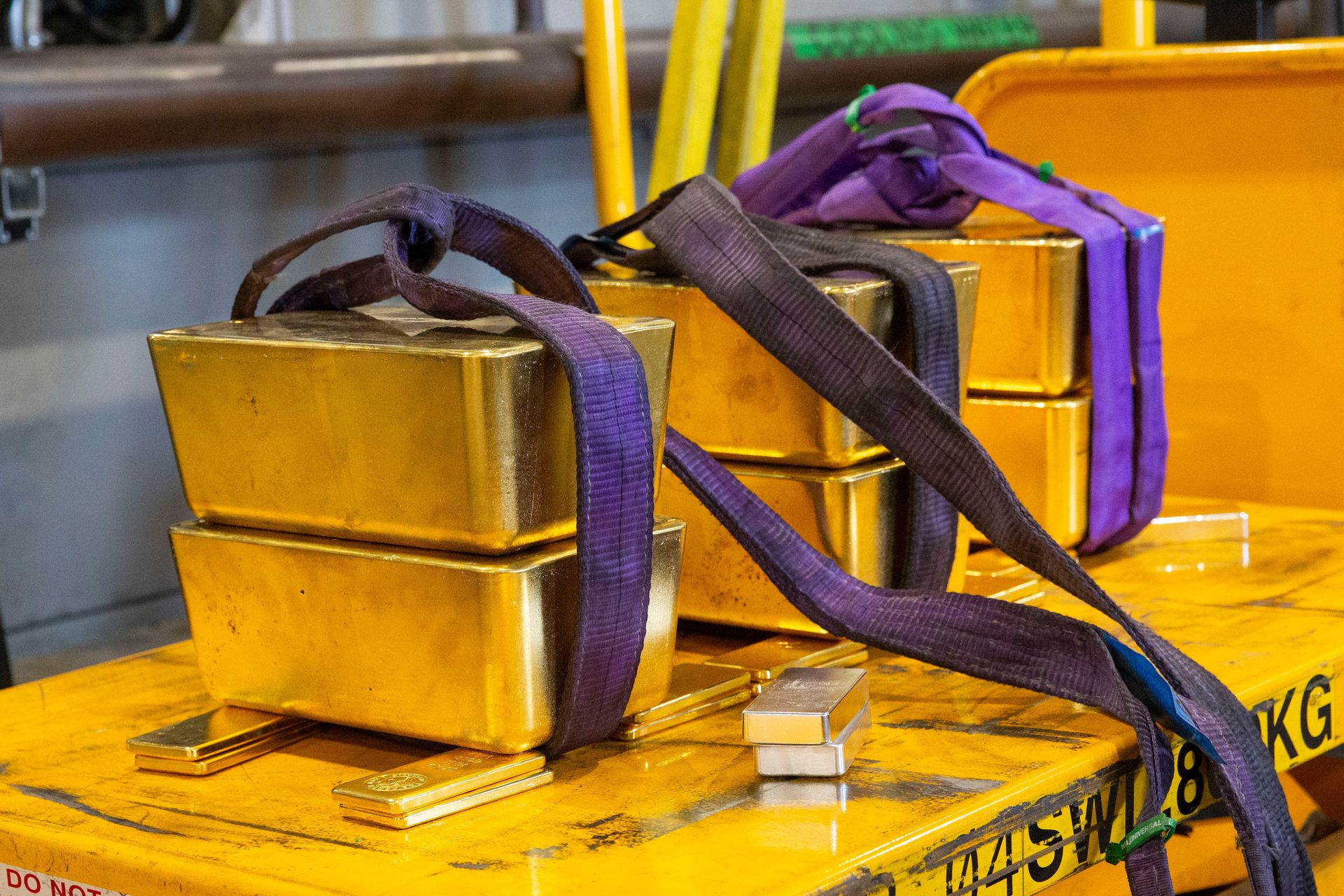 Six large gold bars weighing 85kg each are positioned on an electric trolley