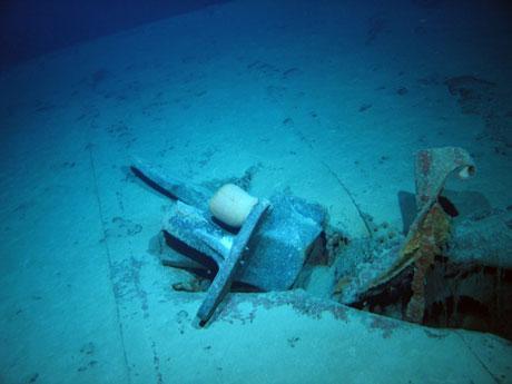 starboard anchor embedded in steel plate from ship‘s side in debris field