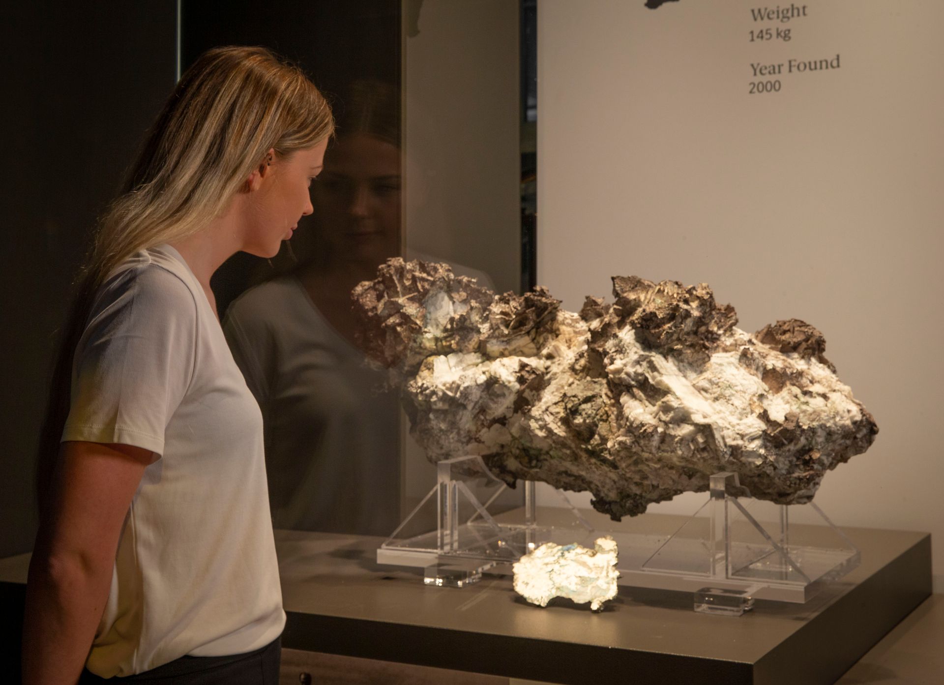 A woman looks at a huge silver specimen in a display case