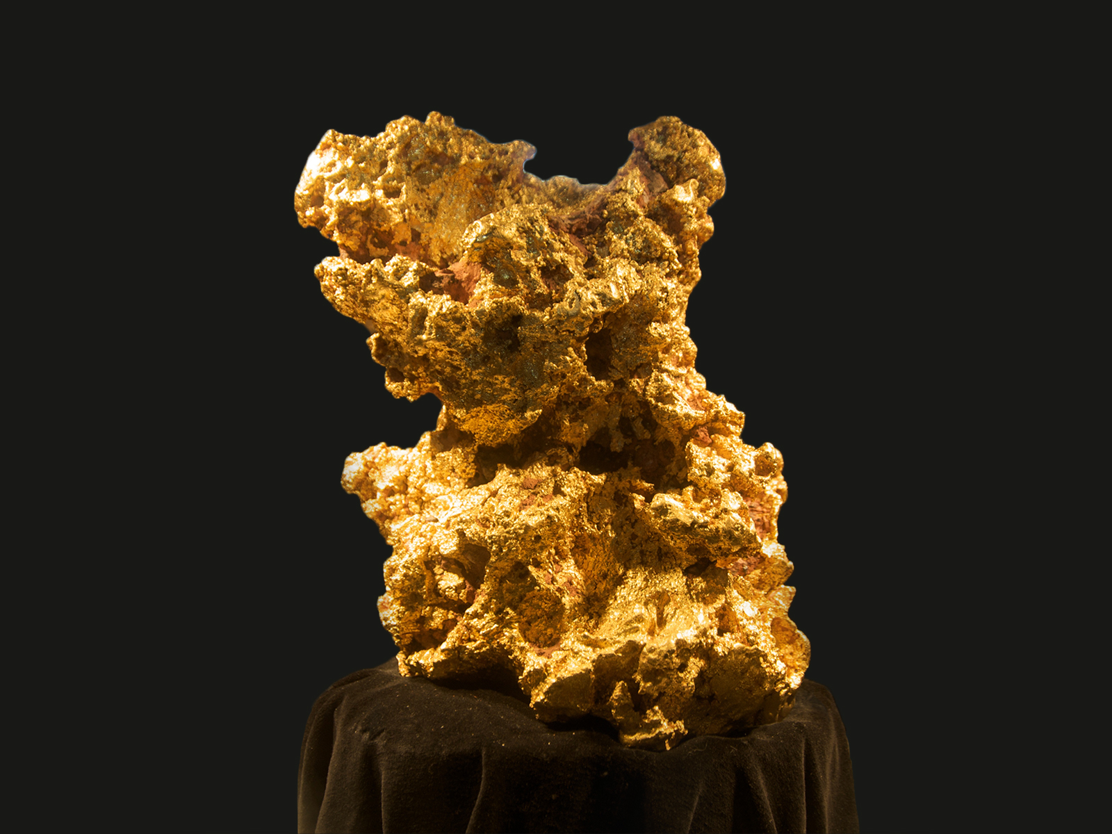 A large gold nugget called 'Newmont's Normandy Nugget' sits on a black plinth