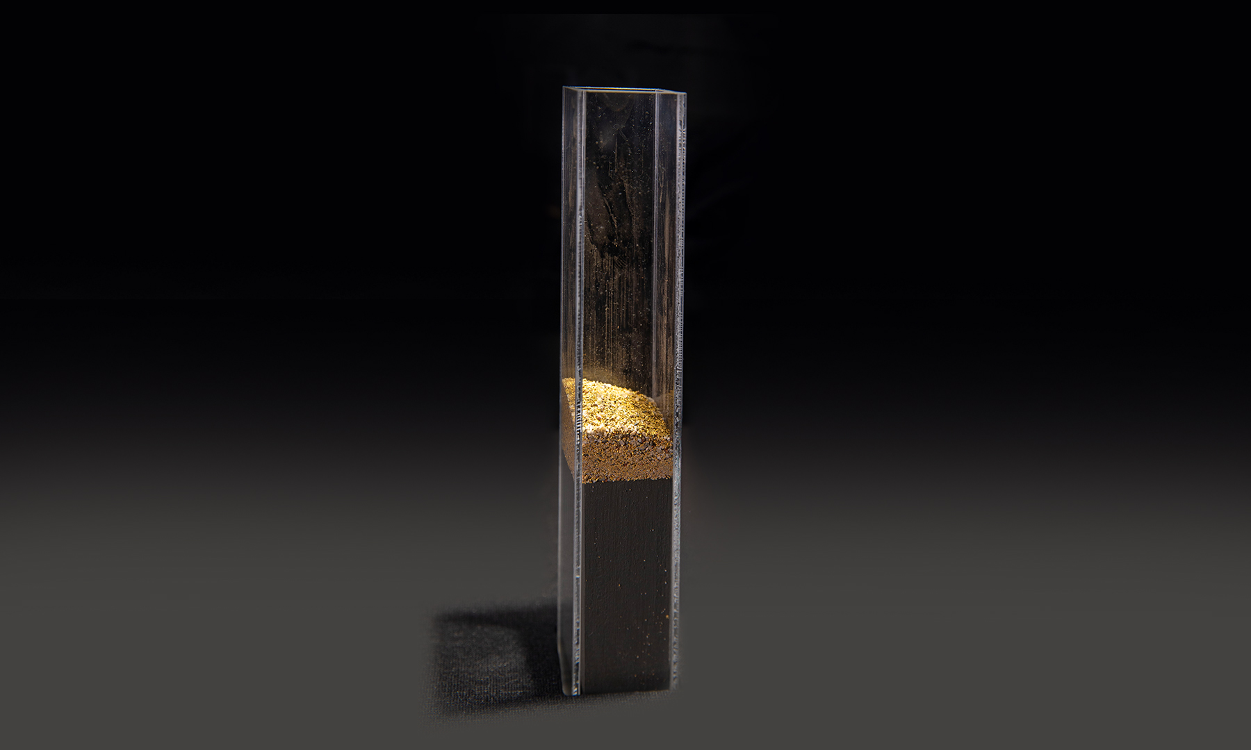 Gold dust on display in a tall acrylic tube