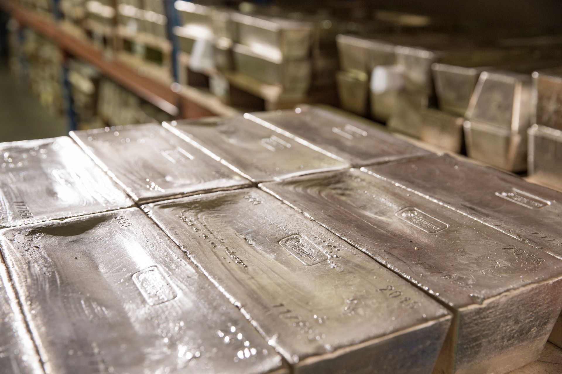 Inside a large walk-in safe full of 1000ounce cast silver bars. Close up in foreground on eight 1000oz cast silver bars