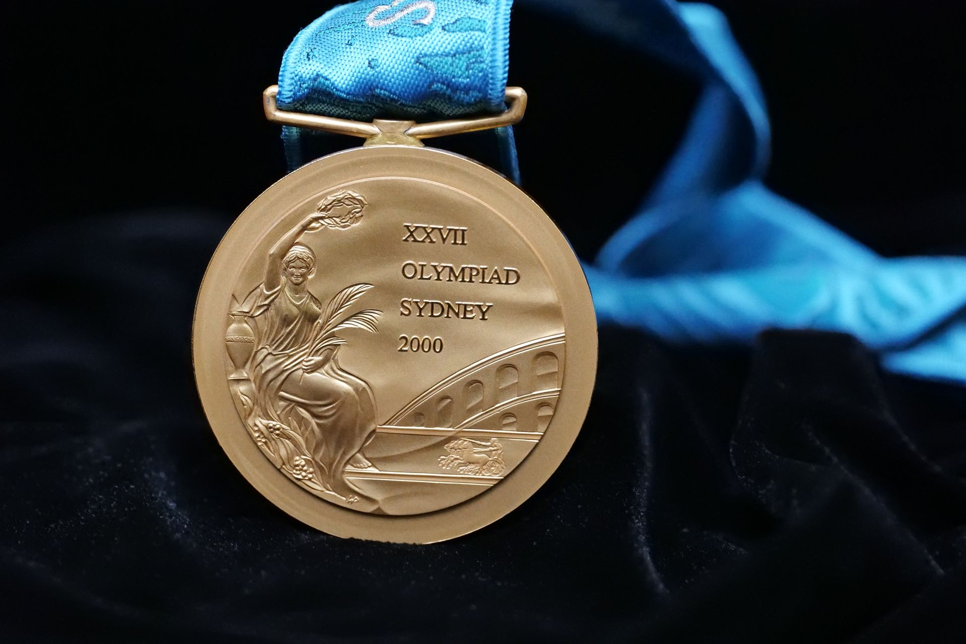 Gold medal 'XXVII OLYMPIAD SYDNEY 2000' with goddess of victory on the left.