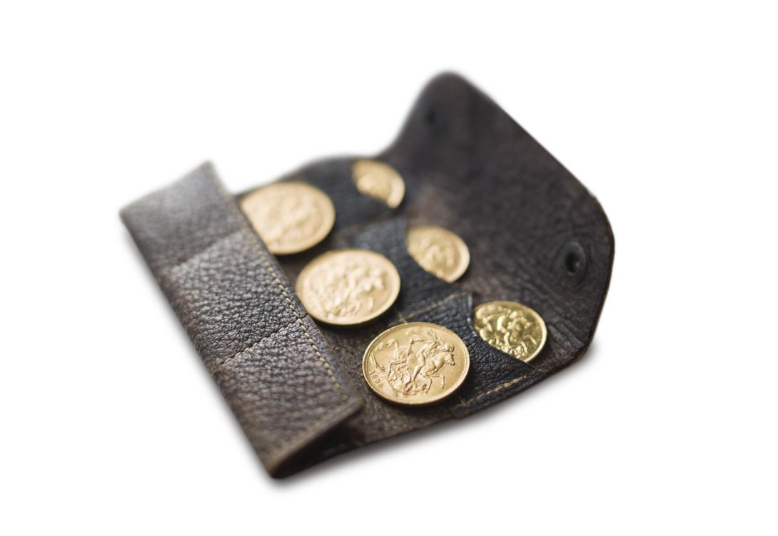 A brown leather wallet with six pockets lies open with six gold coins, three sovereigns and three half-sovereigns visible