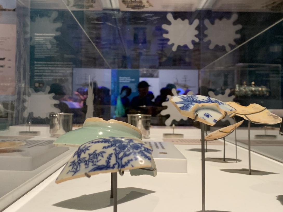 Ceramic sherds displayed on metal stands in a display case.