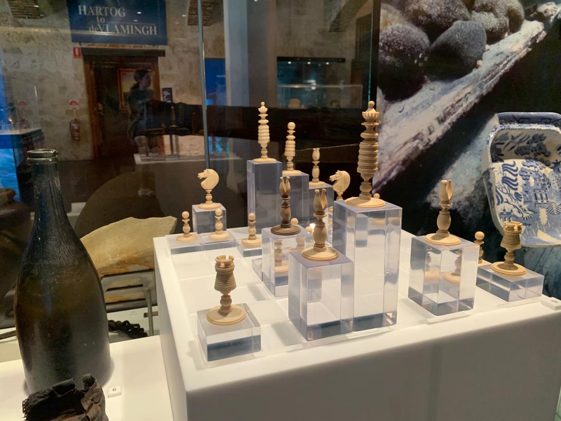 Ivory chess set pieces displayed on acrylic plinths.