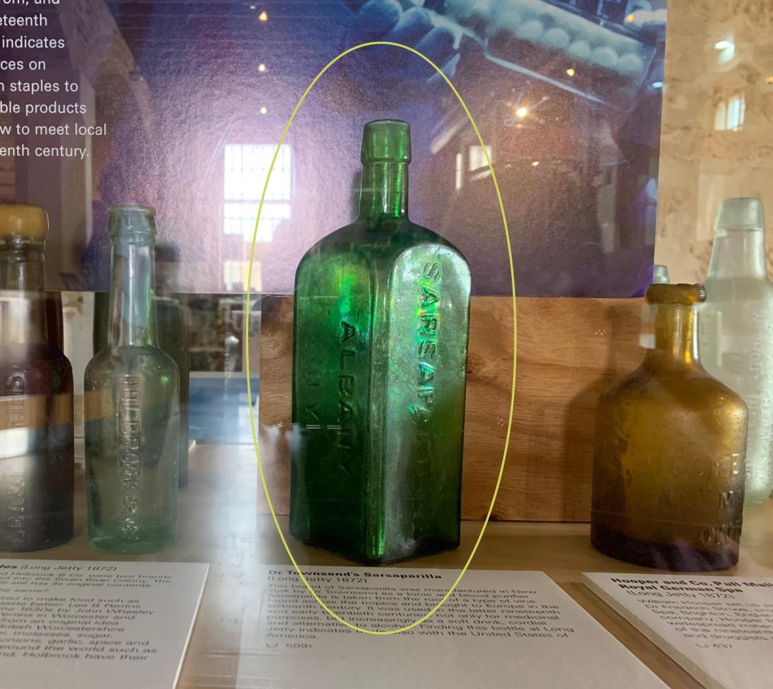A four-sided bright green bottle with 'Sarsparilla' embossed along the side