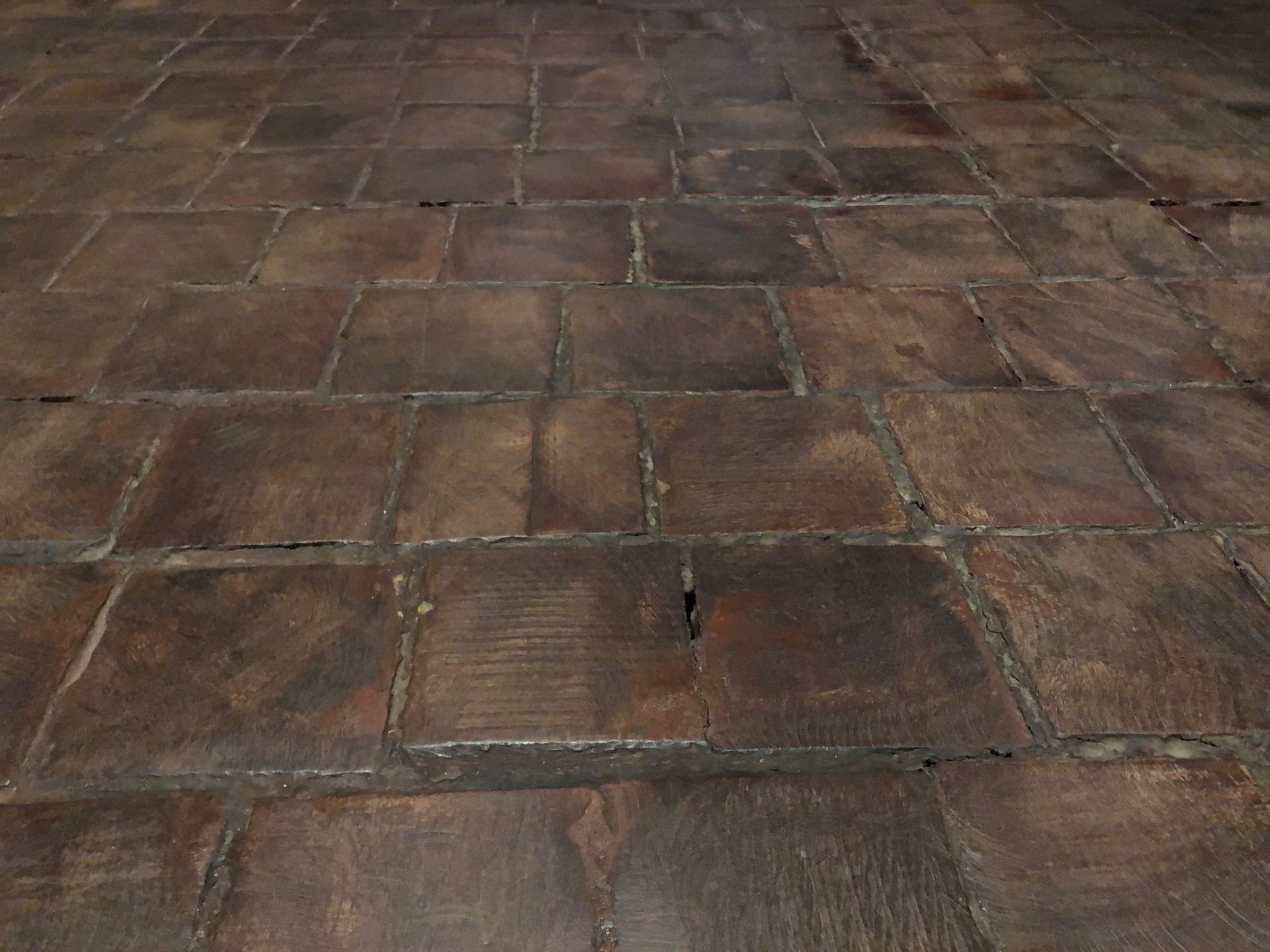 Smooth, square, pieces of wood are laid like tiles on the gallery floor.