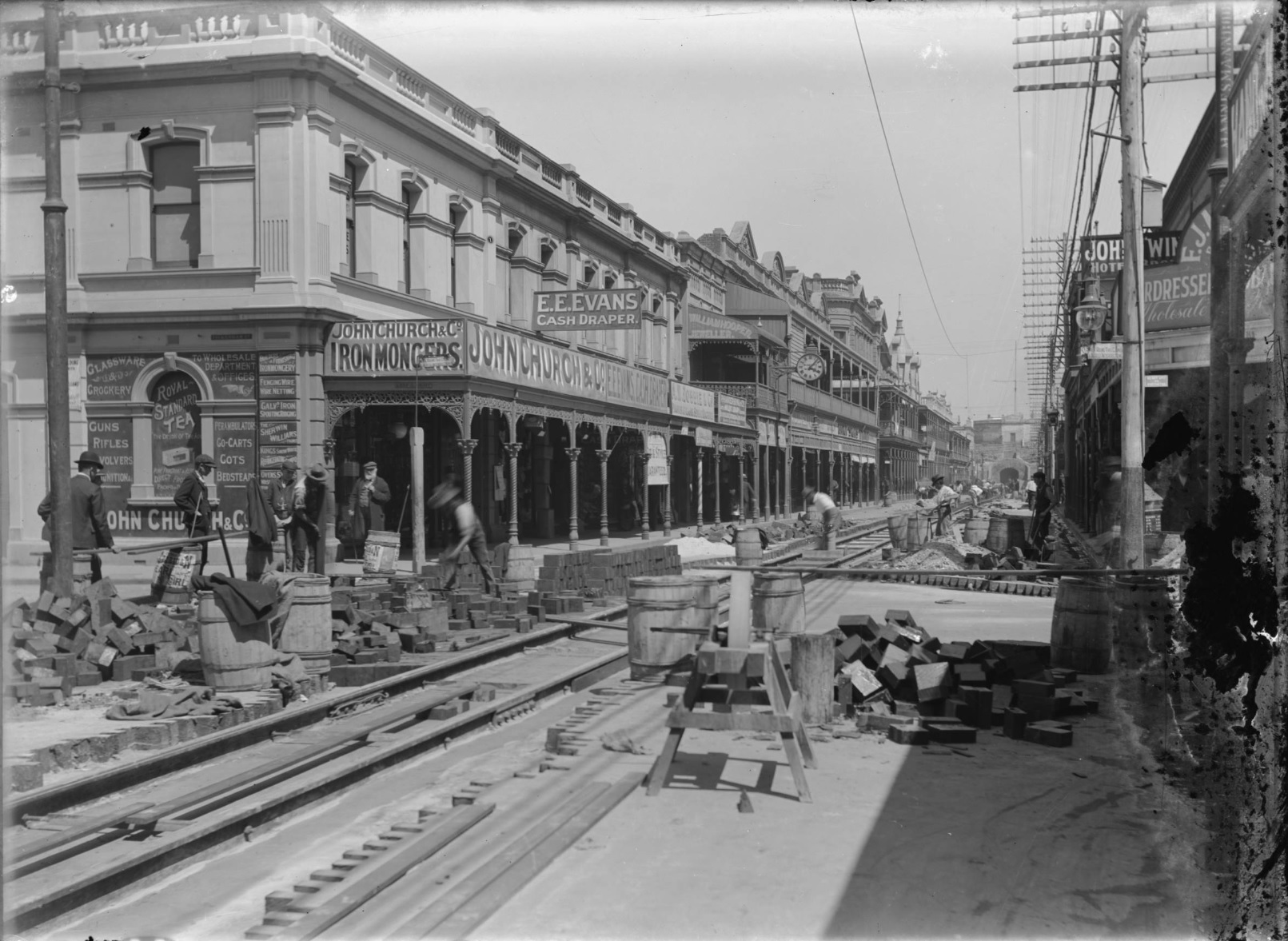 Wooden blocks and equipment for sawing wood can be seen next to the tram line under construction.