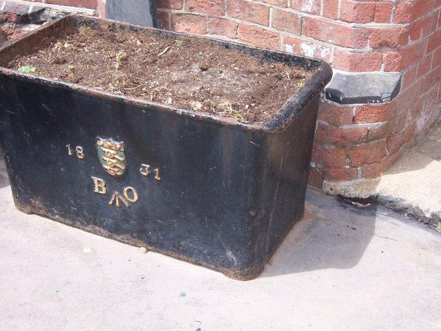 Black painted metal box filled with dirt.