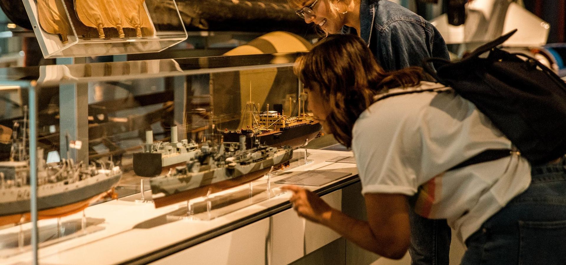 A floor display with military canoes and missiles, and a display case with many model warships form the centre of the gallery.