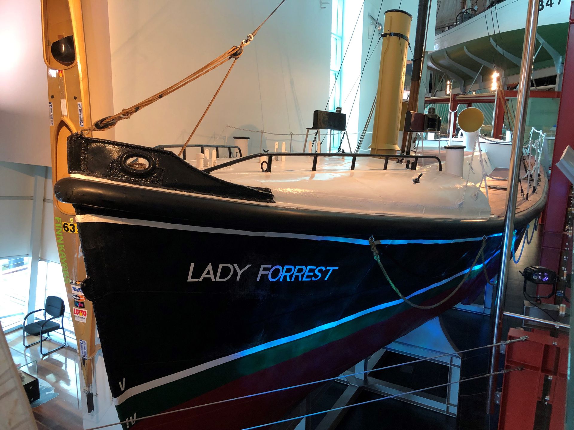 The red and black hull of the Lady Forrest is suspended next to the walkway.