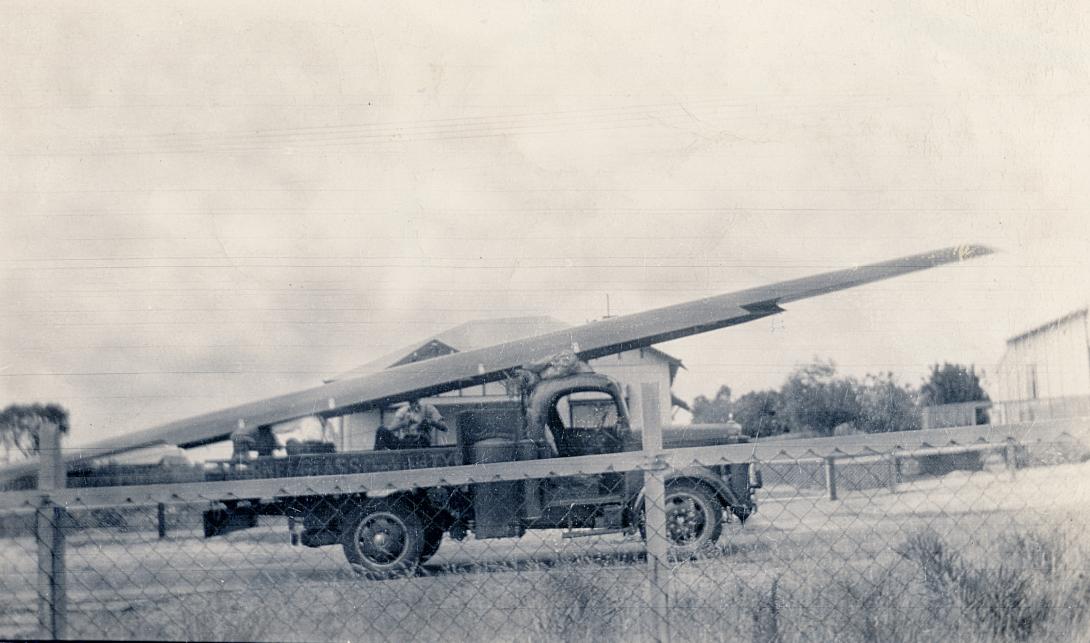 Truck behind fence with rowing shell on roof