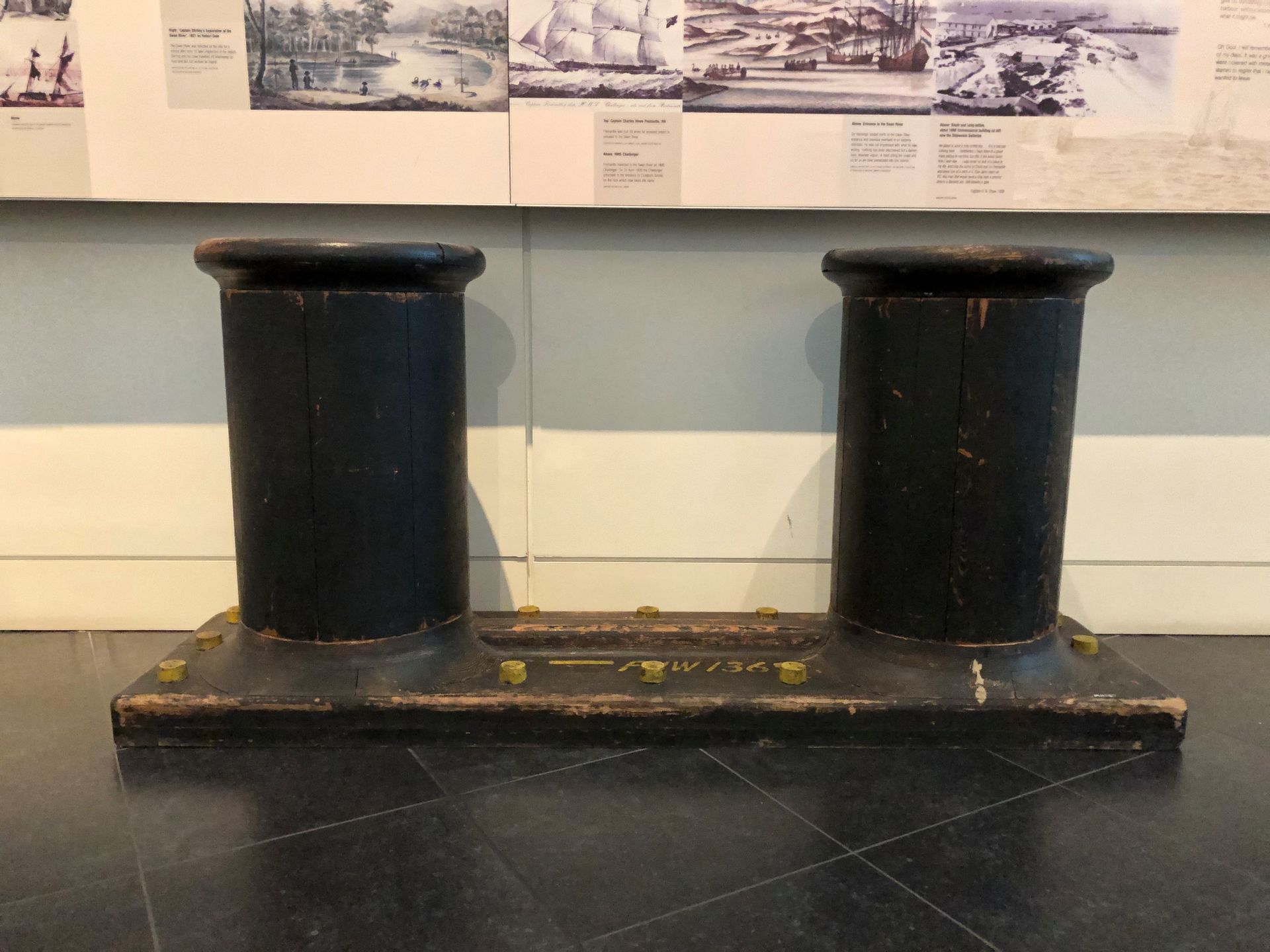 Two large circular bollards mounted with yellow bolts onto the Museum floor.